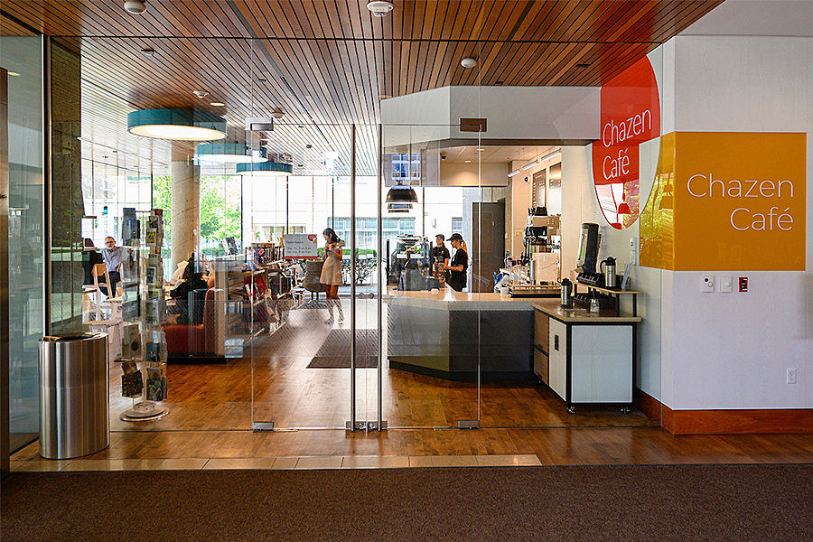 View inside of bright, well-lit cafe with closed glass doors and sign that reads, Chazen Café. 